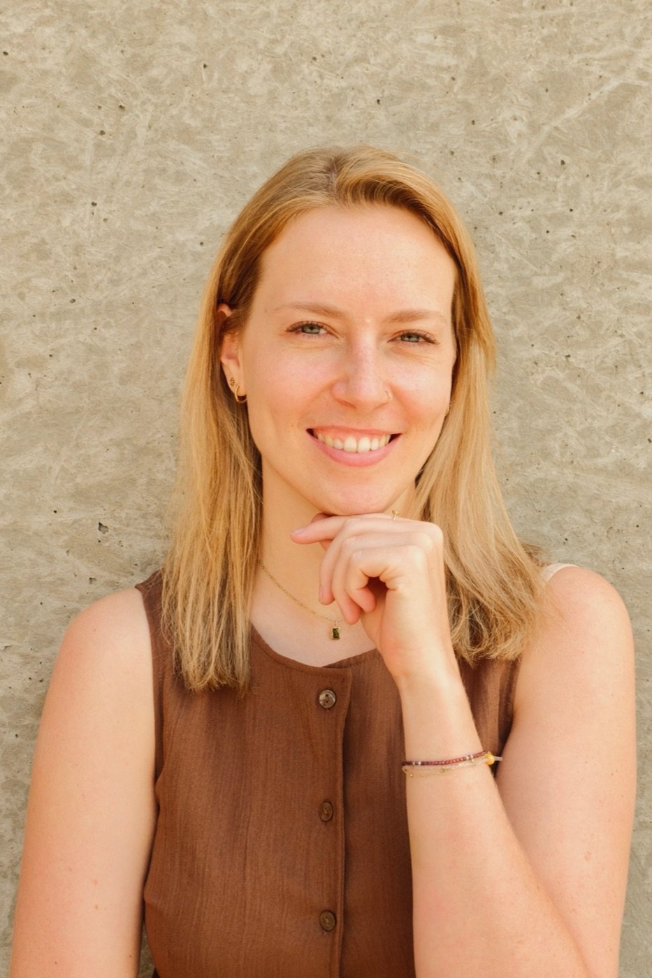 Judith Mietschnig lächelnd, das Kinn auf die Hand gestützt